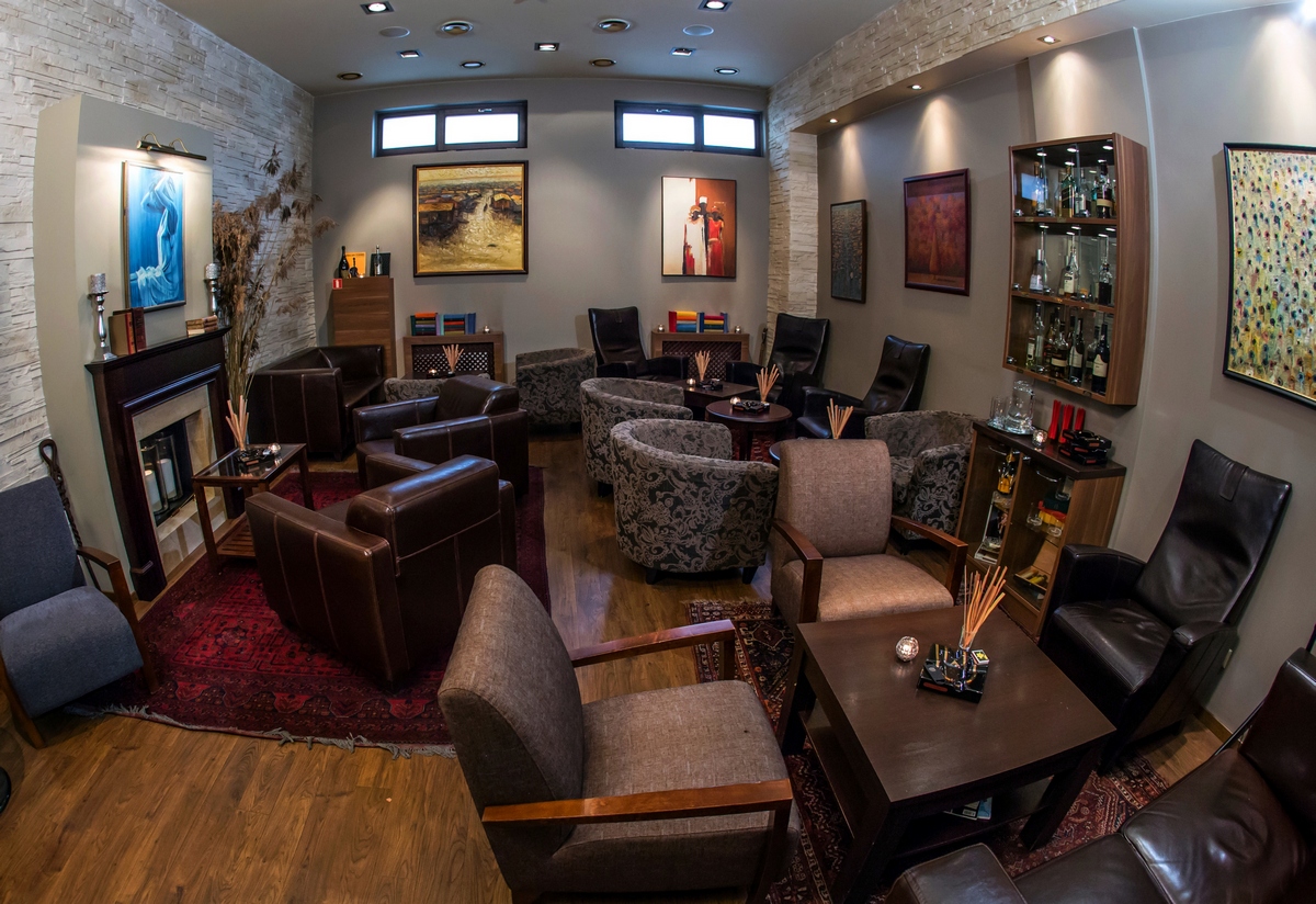 The lounge at The Oak Lounge — leather chairs, rugs and a fireplace